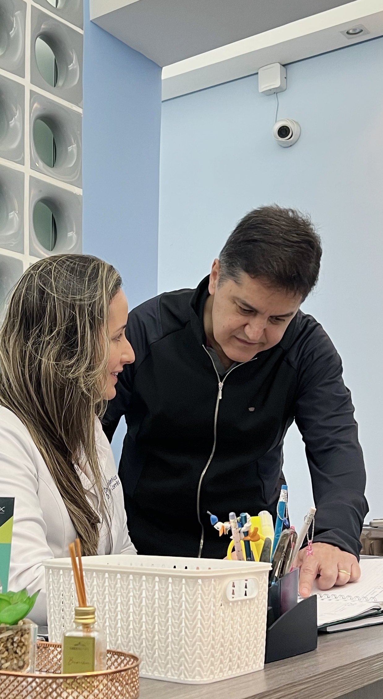 Imagem de uma mesa de atendimento onde se encontra 2 dentistas conversnado